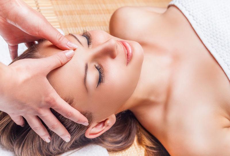 闭眼睛享受面部按摩的美女