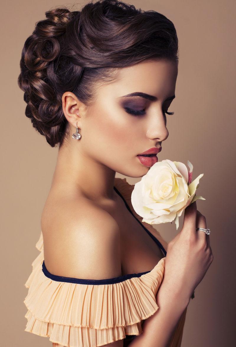 手拿黄色玫瑰的年轻优雅的女子