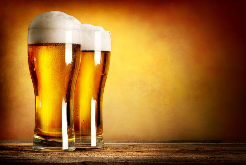 木桌上两杯满满的啤酒