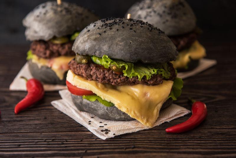木桌上的新鲜美味黑汉堡配牛肉
