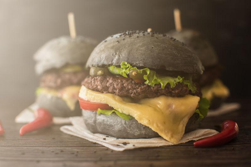 木桌上上的香喷喷的黑汉堡配牛肉