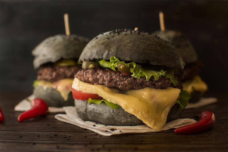 木桌上的黑汉堡配牛肉