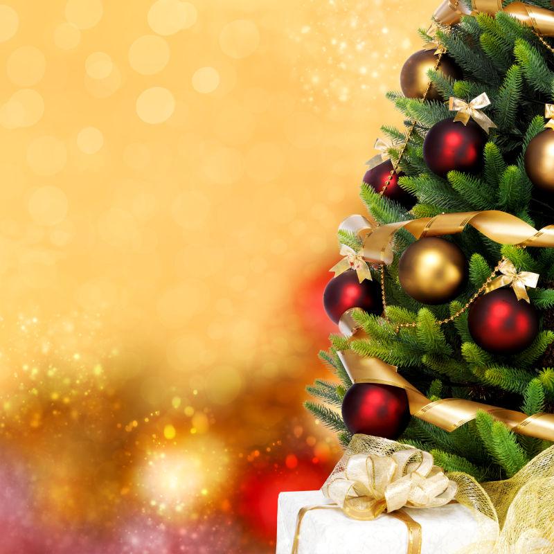 黄色闪光背景下的圣诞树和圣诞礼物盒