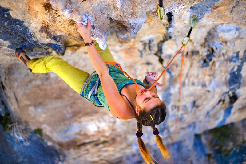 女性攀岩者爬上岩石