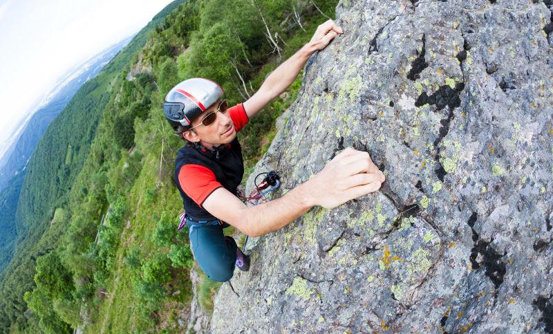 年轻人在山崖边攀岩