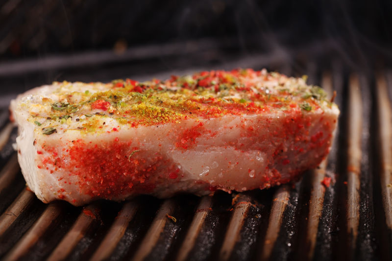 烤架上放了调料的生烤肉