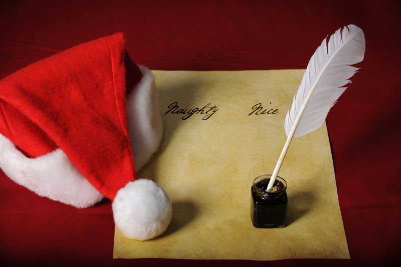 红色背景中的圣诞帽羊皮纸和羽毛笔