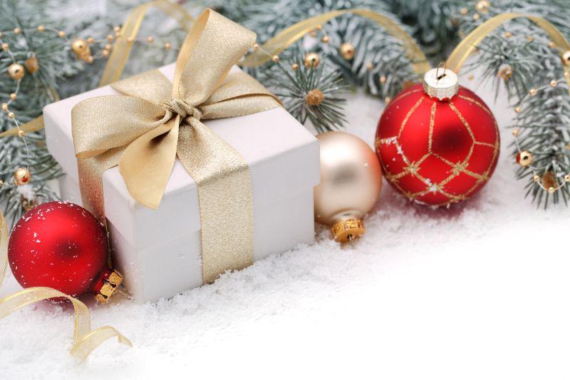 雪地上的白色礼品盒和红色装饰品