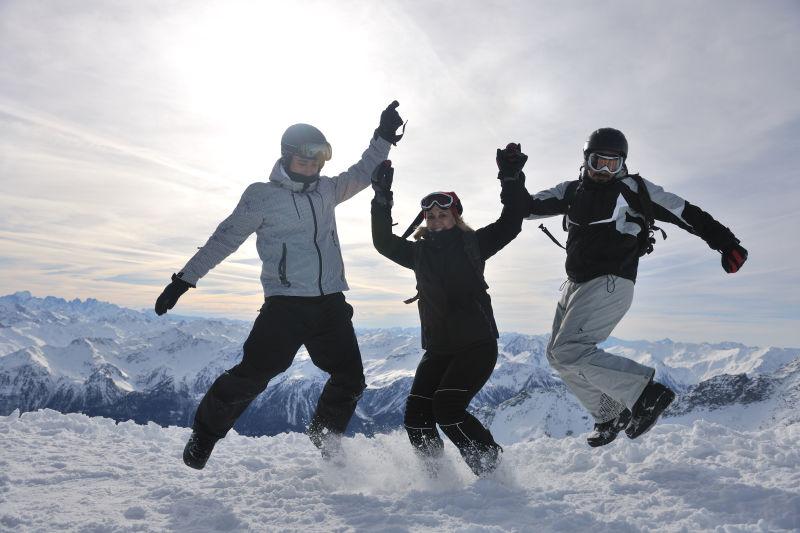 阳光下在雪地上跳起来的滑雪人