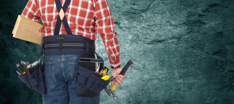 有锤和木板的建筑工人