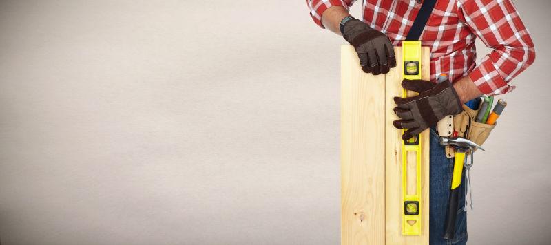 建筑工人在灰色背景下使用建筑工具