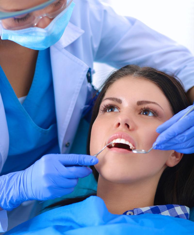 正在为年轻美女检查牙齿的美女