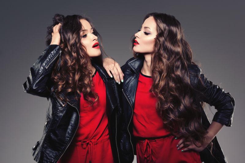 灰色背景下的两个年轻时尚的美女