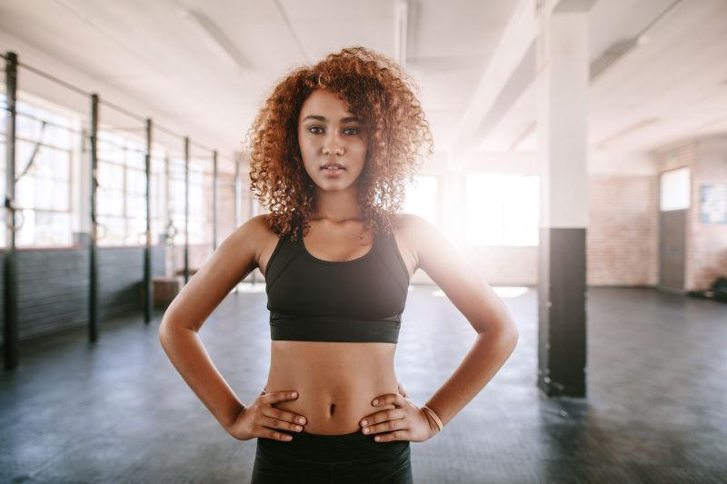 健身房背景中穿黑色运动服的美女