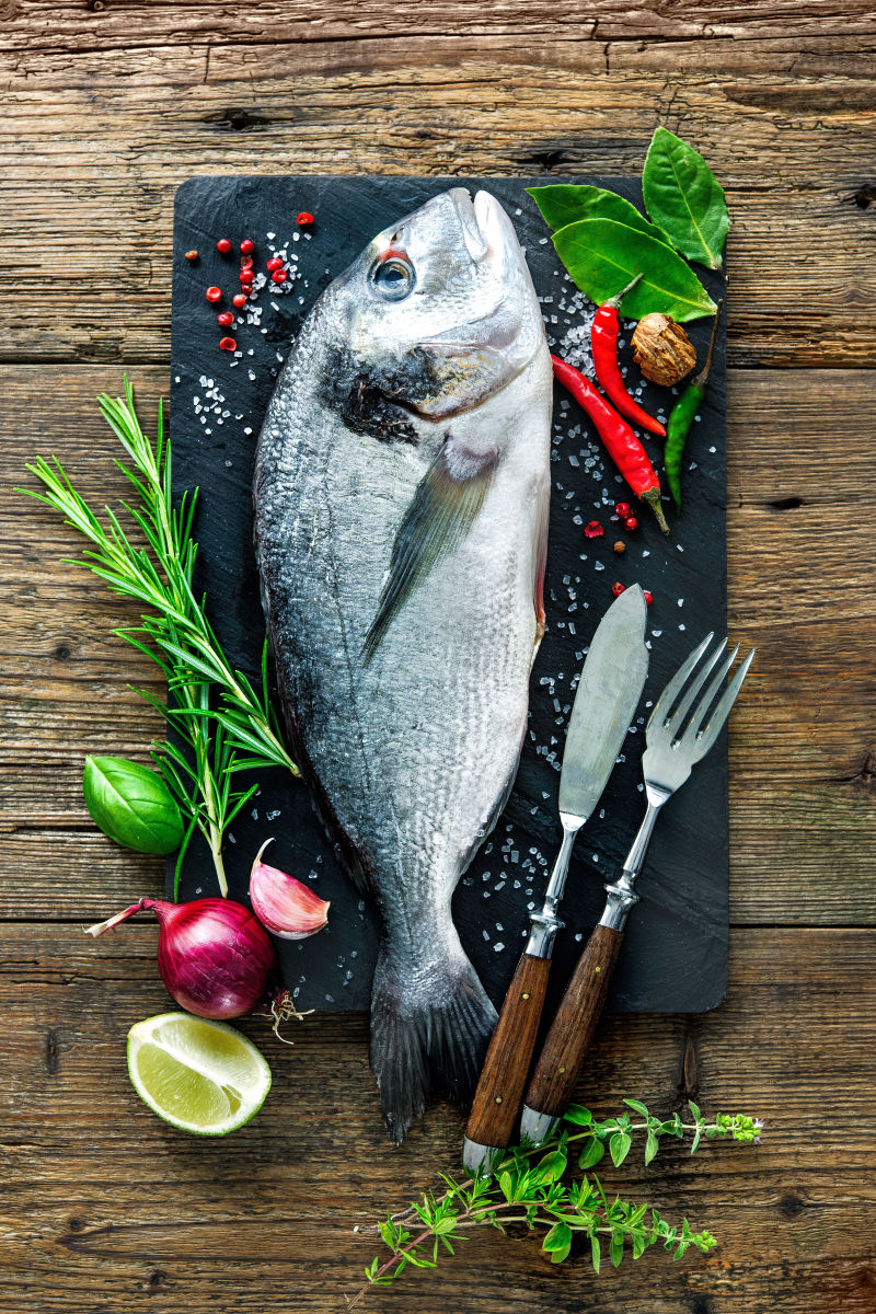 一条新鲜的金丝鲷与调味料