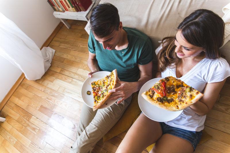 年轻夫妇在吃比萨饼
