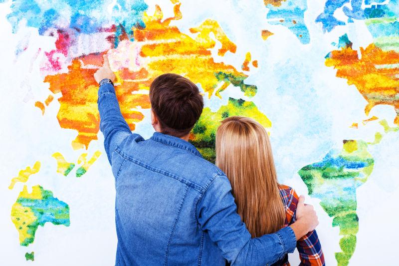 一起看世界地图的年轻夫妇