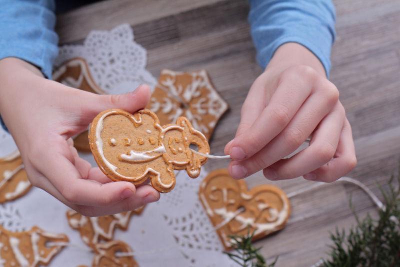 小孩用姜饼做圣诞树装饰