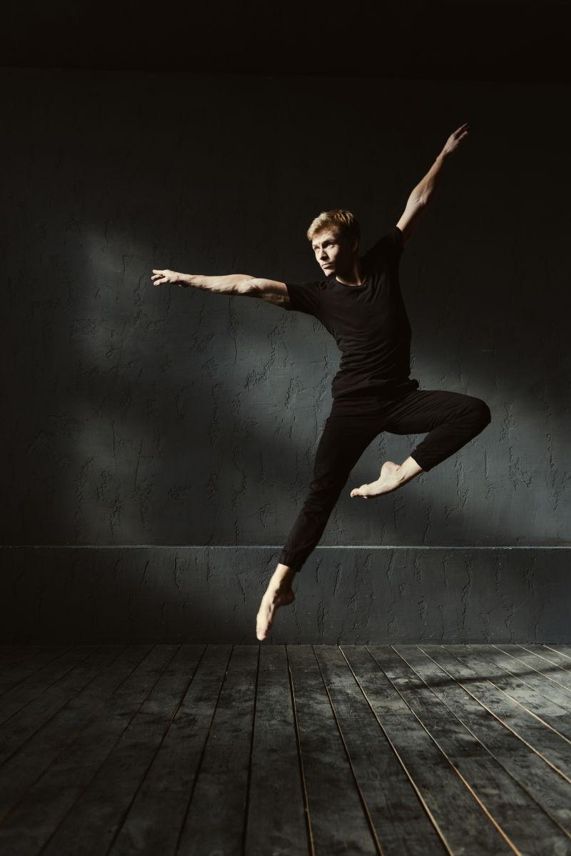 年轻舞者在漆黑的房间里跳舞