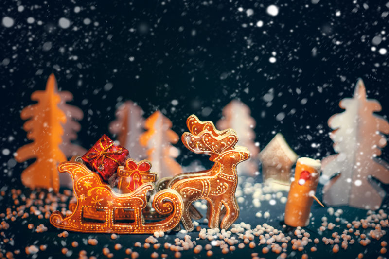 圣诞驯鹿在雪盖的森林里送礼物