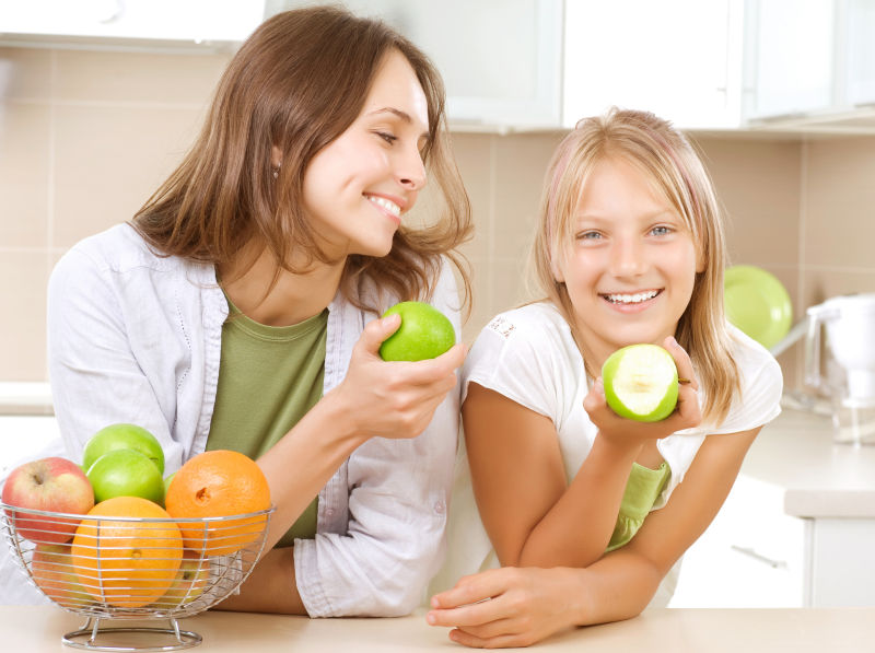 快乐的母亲和女儿吃健康的水果