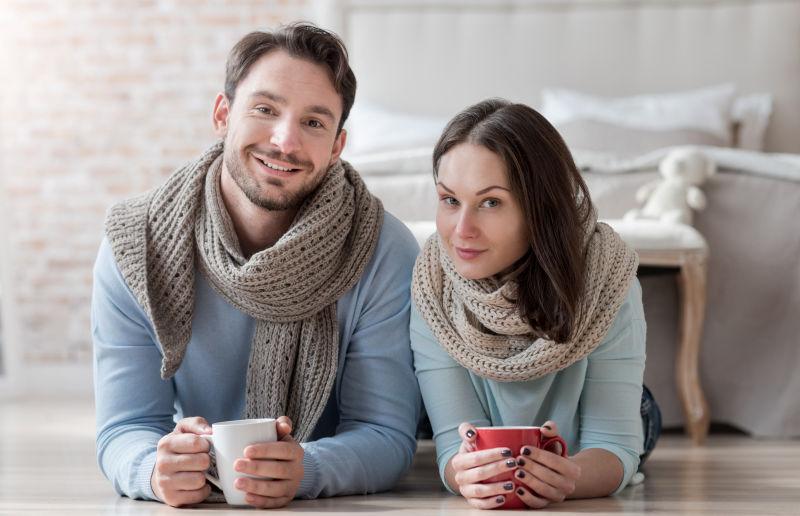 躺在室内地板上的一对年轻情侣