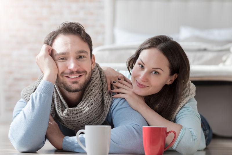 室内地板上躺着的一对情侣