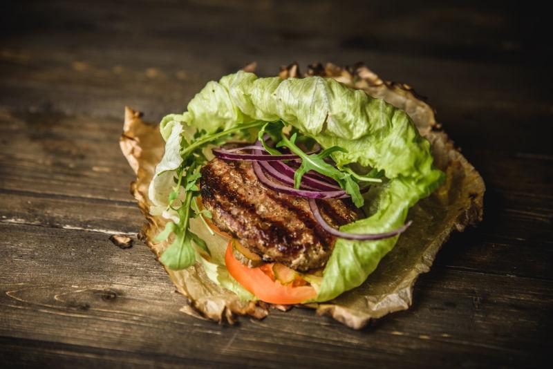 木制烧纸上的卷生菜汉堡