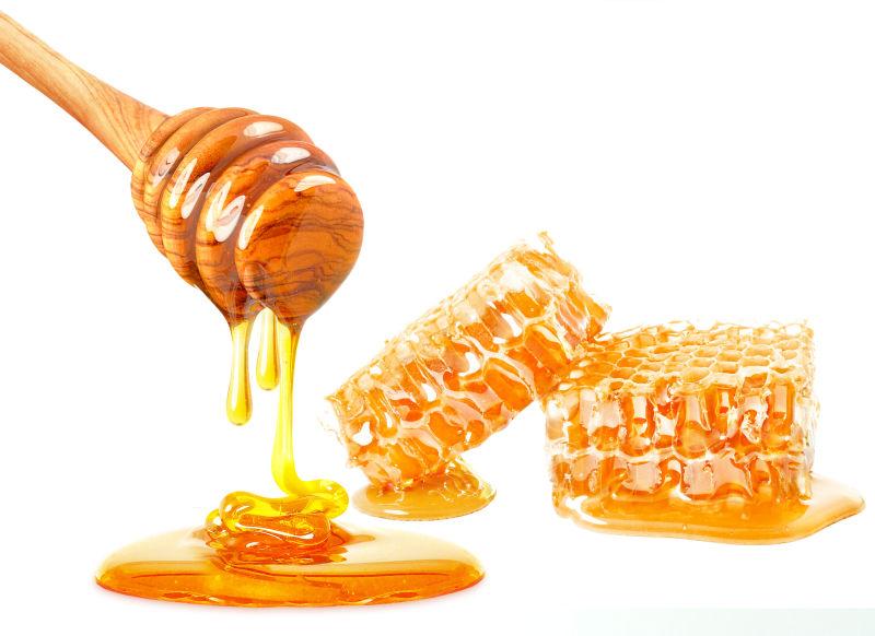 白色背景下的新鲜美味的蜂蜜和蜂巢