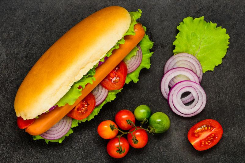 黑色桌子上的蔬菜和热狗