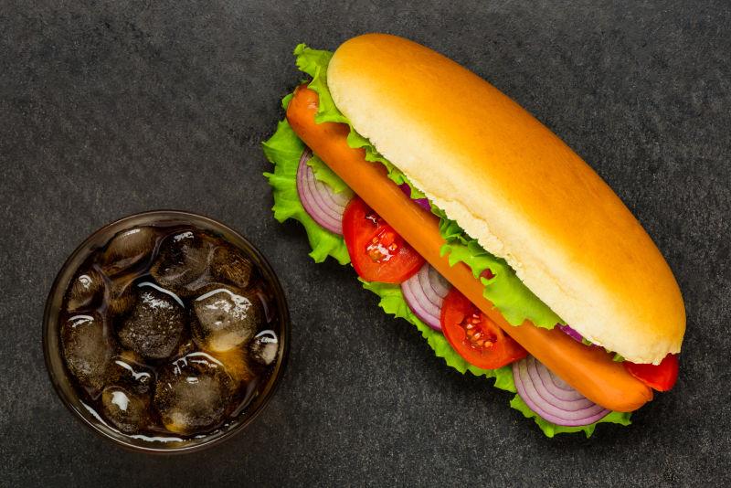 黑色桌子上的热狗和冰镇可乐