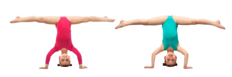 白色背景中做倒立的体操小女孩