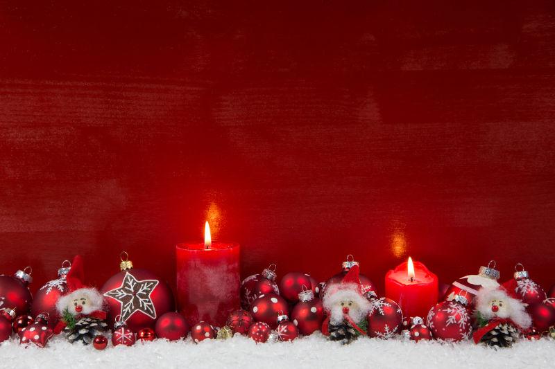 红色背景中燃烧的红色蜡烛和圣诞节装饰品