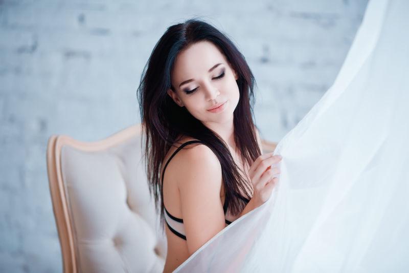 坐在椅子上拉着窗帘的性感美女