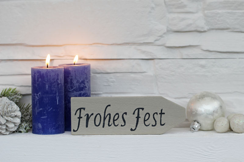 在白色背景墙背景下燃烧的圣诞蜡烛