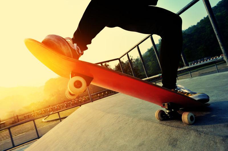 夕阳下滑板公园玩滑板的年轻人