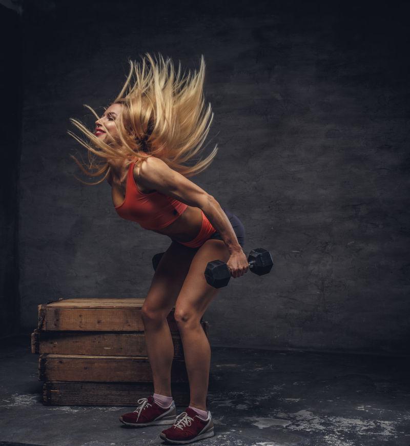 金发美女拿着哑铃健身