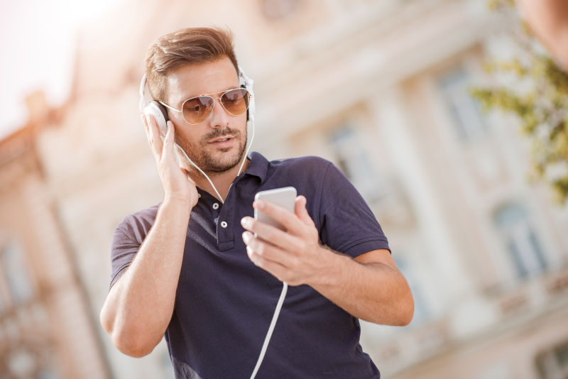 戴耳机玩手机的男人