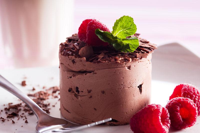 白色盘子里的带着浆果的巧克力慕斯甜点