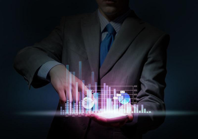 黑色背景下男人用手操控掌上虚拟图形在工作中的应用