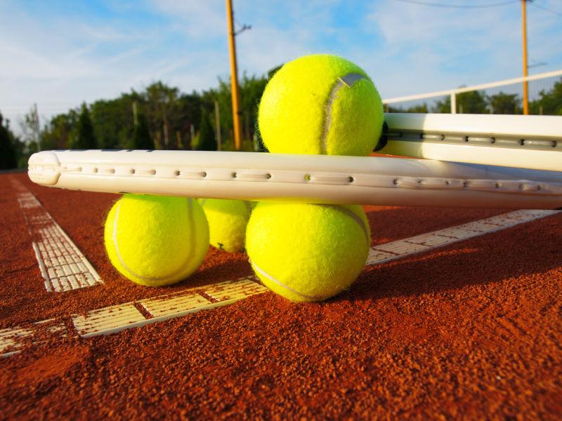 网球场地上的黄色网球和网球拍