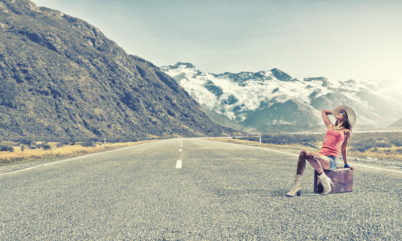 旅行者坐在手提箱上休息