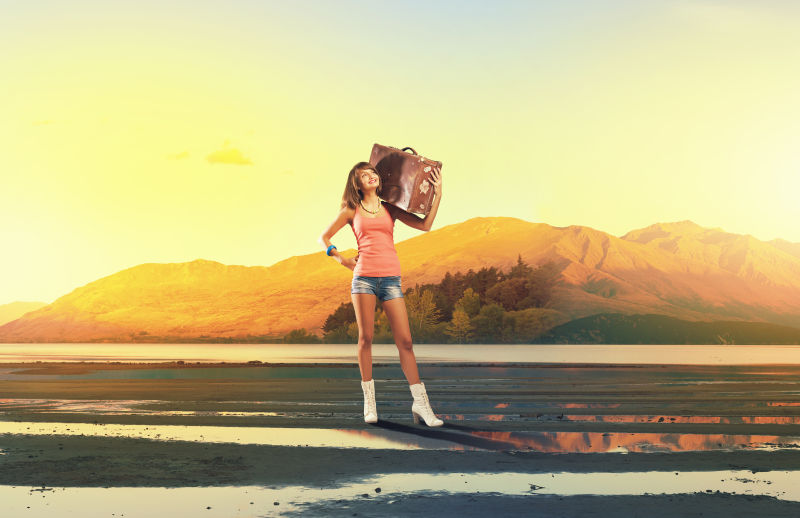 旅行者妇女肩上扛着复古手提箱