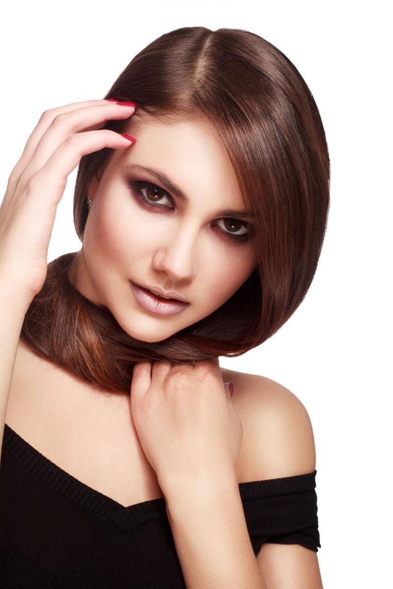 在白色背景下性感自信的美丽女人拥有健康的长发