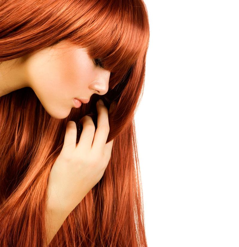 在白色背景下拥有健康的红色头发的美女