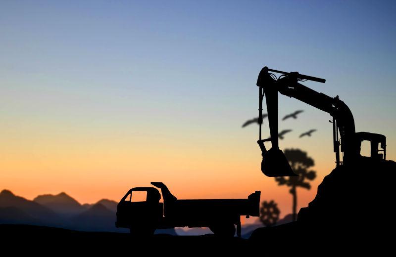 夕阳下的挖掘机和卡车