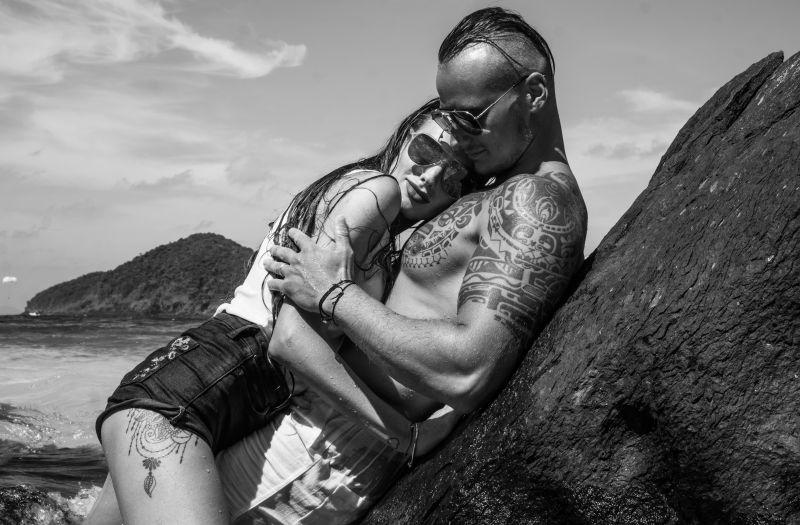 海边岩石上抱在一起的情侣