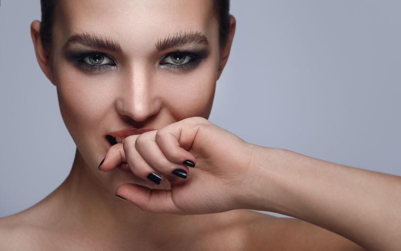 灰色背景中化妆的时尚女人