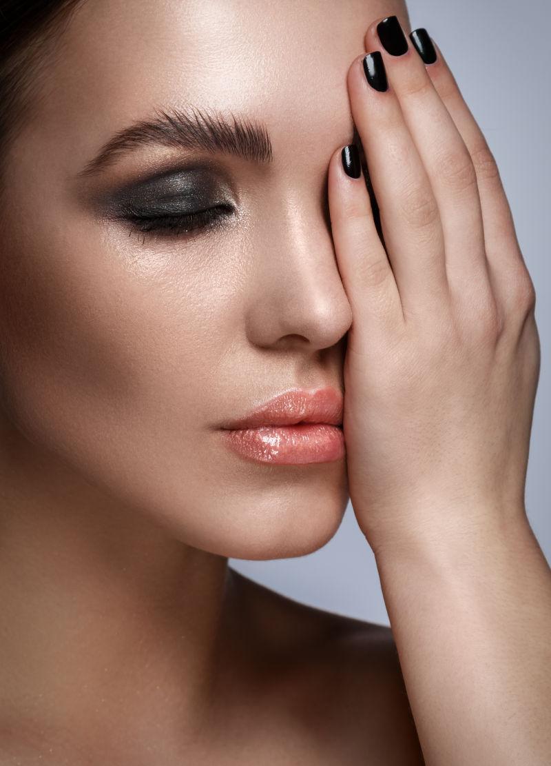 灰色背景中化烟熏妆的美女