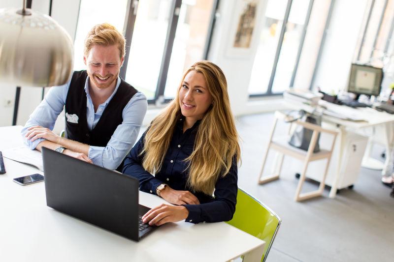 办公室里的笔记本电脑前的两个商人